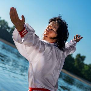 Tai Chi Chuan with arms spread, in nature